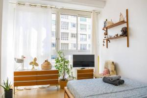 马赛Le Gabian的一间卧室设有一张床、一台电视和一个窗口。