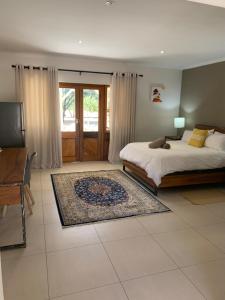 奥奇瓦龙戈Otjibamba Lodge的一间卧室配有一张床、一张桌子和一台电视