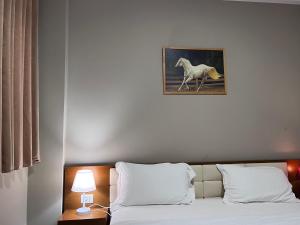 斯库台Bobi Hotel的一间卧室,配有一张带马匹照片的床