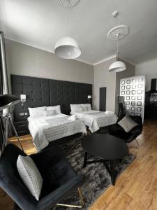 格拉斯哥Amani Apartments - Glasgow City Centre的一间卧室配有两张床、一张沙发和一张桌子