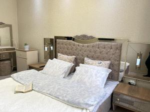 杜尚别Large modern apartment mix style的卧室配有一张带白色床单和枕头的大床。