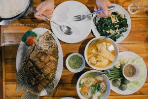 Ban Chieo Ko帕维里度假酒店的餐桌,盘子上放着食物和碗