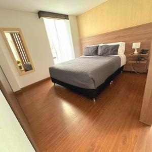 波哥大Cómodo Apartaestudio en super ubicación的一间卧室配有一张床,铺有木地板
