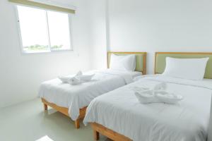 董里S1 Trang Hotel的一间设有两张床铺的房间,上面放有碗