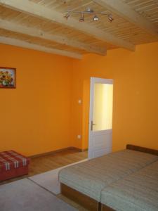 鲍科尼贝尔Sárgarigó Vendégház的一间卧室设有橙色的墙壁和门