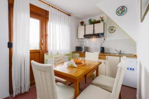 斯诺基Apartment Žalac的厨房配有木桌和白色椅子