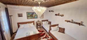 培拉特Guesthouse Alvaro Kadiu的一间卧室配有两张床和吊灯。