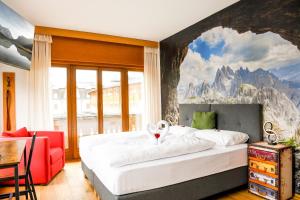 多比亚科Guesthouse Rosengarten的卧室配有一张大床,墙上挂有山壁画