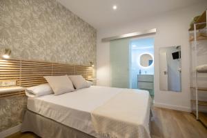 蓬塔翁布里亚Hostal Royal Bliss的一间带白色大床的卧室和一间浴室