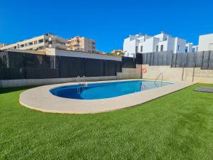 贝纳哈拉菲Terrace Mares de Benajarafe - Alojamientos La Torre的草场中央的游泳池