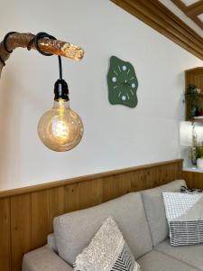 拉兹洛格Pirin Golf & Spa Greenside Studio的挂在沙发上的灯,墙上挂着一个钟