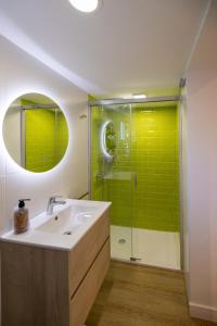 蓬塔翁布里亚Hostal Royal Bliss的浴室设有水槽和绿色瓷砖淋浴。