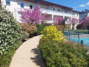 图尔Appartement 65 m² avec piscine.的紫色花前的走道