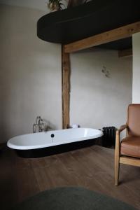 蒙特勒伊格雷诺伊勒尔酒店的浴缸位于带椅子的房间内