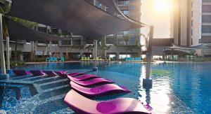 马六甲Atlantis Residences By 360 HOME的一座带紫色躺椅的游泳池