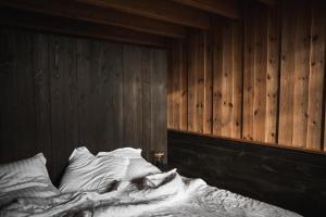 蒙特勒伊格雷诺伊勒尔酒店的木墙客房的一张未铺好的床