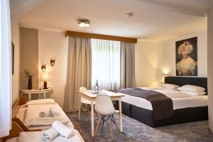 巴登-巴登赫希兰德卡斯托酒店的酒店客房带一张床、一张桌子和椅子