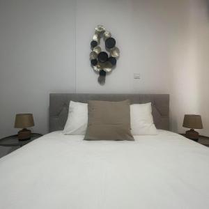 尼科西亚Glamorous, Renovated 3-Bedroom Apt in Nicosia的一间卧室配有一张带两盏灯的大型白色床。