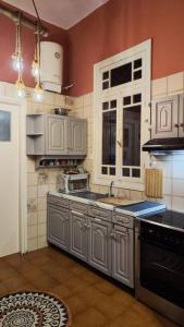 比雷埃夫斯Yellow and blue relax house的厨房配有白色橱柜、水槽和炉灶。