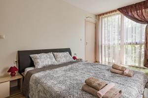 瓦尔纳Garden Palace的一间卧室配有一张大床和两条毛巾