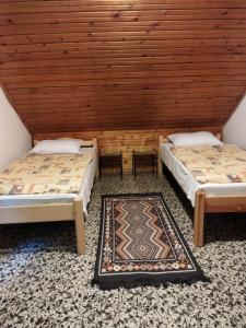 毛焦尔海尔泰伦德Mecsek Virágai Lak的配有木天花板的客房内的两张床