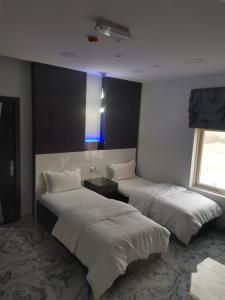 索哈尔Marina H的一间卧室配有两张床和蓝色的灯光