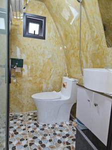 海阳Mio Hotel的浴室配有卫生间、盥洗盆和淋浴。