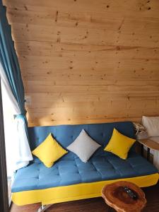 海阳Mio Hotel的客房内的蓝色沙发,配有黄色枕头