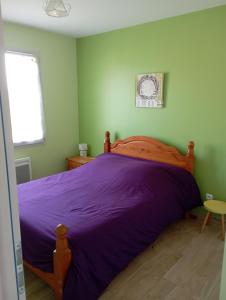 NexonLE JOLICY的一间卧室配有一张带紫色床单的大床
