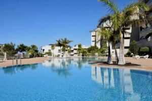 滨海帕尔姆Luxuriöse Duplex Ferienwohnung in sehr ruhiger Wohnanlage mit Meerblick的一座棕榈树和建筑的大型游泳池