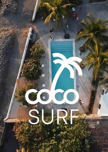 拉利伯塔德Coco Surf Tropical Village的棕榈树建筑的一侧的标志