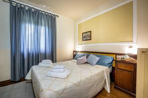 比萨密涅瓦酒店的一间卧室配有带毛巾的床