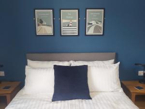 托特兰Bay House的床上方有四张照片的蓝色墙