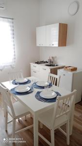 伊斯皮卡IL GUFO DELLA MARZA的厨房配有白色桌子和四把椅子