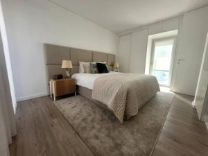 吉马良斯Cidade_Berço House的白色的卧室设有一张大床和一个窗户