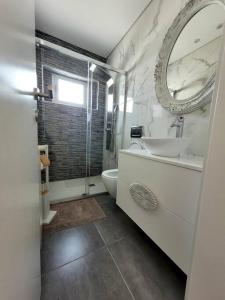 吉马良斯Cidade_Berço House的一间带水槽、卫生间和镜子的浴室