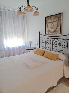 阿亚蒙特Relax Apartment Costa Esuri的一间卧室配有一张床,上面有两条毛巾