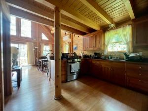Beddington Lake Log Cabin的厨房配有木制橱柜和炉灶烤箱。