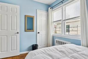 Wave CrestRockaway 3 bedroom suite by the Sea.的一间拥有蓝色墙壁的卧室、一张床和窗户
