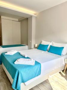 维亚纳堡Enjoy Viana - Guest House的卧室配有带蓝色枕头的大型白色床