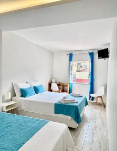 维亚纳堡Enjoy Viana - Guest House的一间白色卧室,配有两张床和窗户
