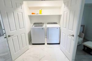 隆格伊Stylish and luxurious apartment basement unit的小厨房配有两台洗衣机,厨房设有门