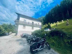 日腾Alpenpension Gasthof的停在大楼前的一排摩托车