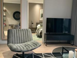 米德兰5 Star Elegant Apartments, Ellipse Waterfall City, Midrand, Johannesburg的客厅配有椅子和平面电视