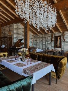 斯基希德尼萨Парк-готель Щастя的一间带桌子和钢琴的用餐室