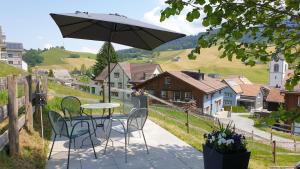 UrnäschHaus an sonniger Lage, schöner Blick auf Alpstein的庭院配有桌椅和遮阳伞。