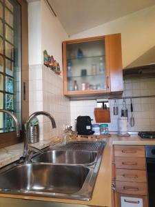 菲乌米奇诺Andrea's House的厨房配有不锈钢盥洗盆和橱柜