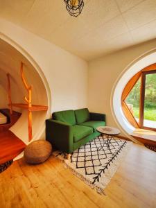 FatelaCasa Florestal - Fatela - Hobbit House , Cabins的客厅设有绿色沙发和窗户。