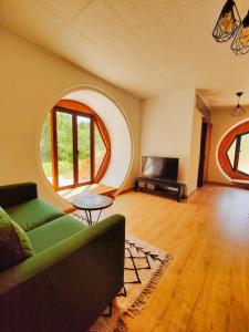 FatelaCasa Florestal - Fatela - Hobbit House , Cabins的带沙发和圆形窗户的客厅