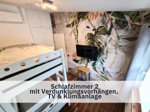 罗特Ferienhaus Rothsee-Oase ideale Ausgangslage mit tollem Ausblick, Sauna und privatem Garten的卧室配有一张床,墙上挂有绘画作品